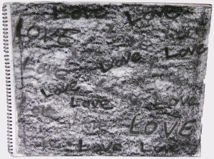 A drawing in a spiral notebook. Charcoal rubbing forms the background. The word 